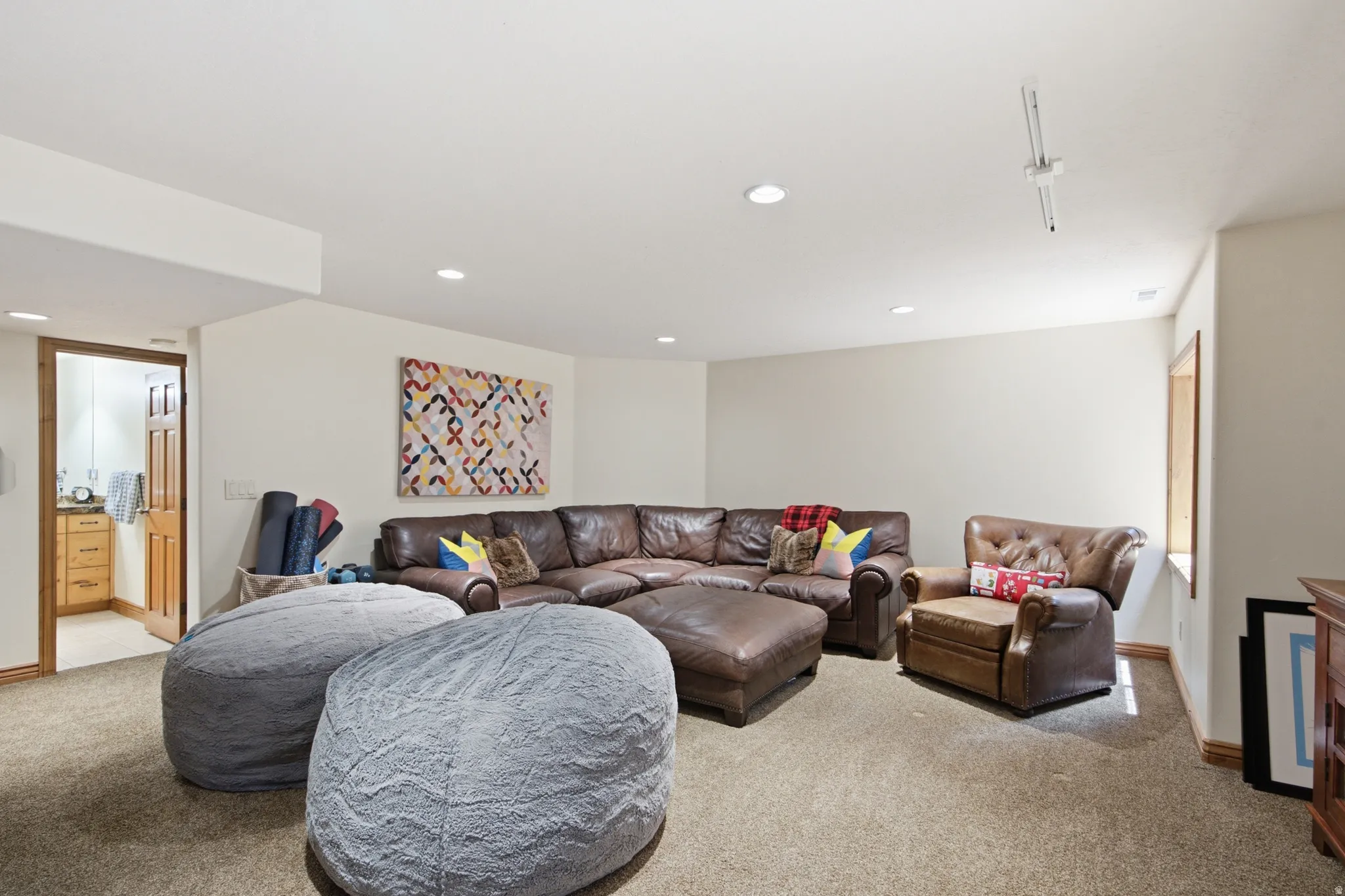 Carpeted room featuring recessed lighting and a window with wood trim