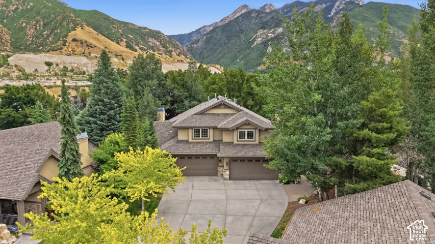 Two-story residence featuring a multi-gabled roofline and a stone and stucco facade