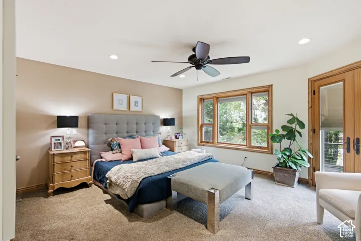 Spacious room featuring a multi-pane window, wood-finish French doors, a ceiling fan with light, recessed lighting, and soft carpet flooring