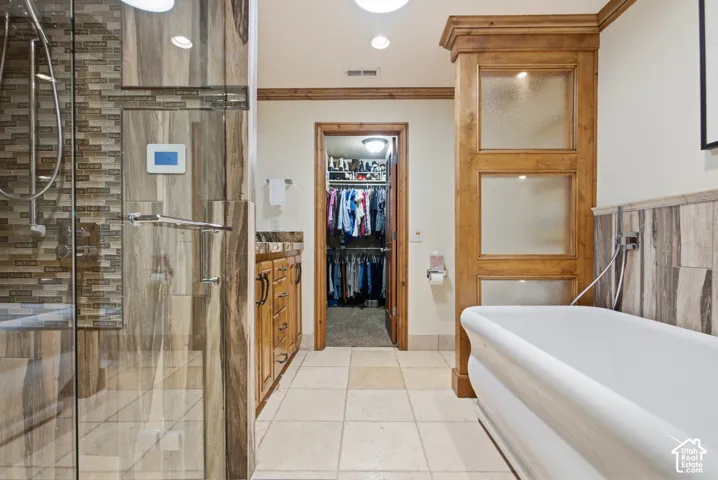 Shower enclosure with glass panel, integrated digital shower control, and mosaic tile accents