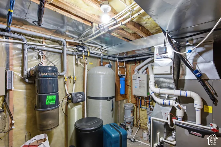Utility space featuring a central vacuum system, water filtration unit, water softener, and HVAC system with exposed ductwork