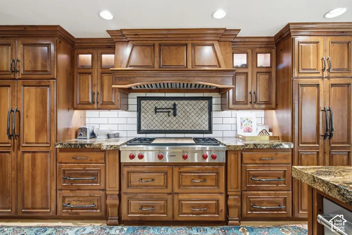 Gourmet kitchen with rich wood cabinetry, a professional-grade stainless steel range, and granite countertops