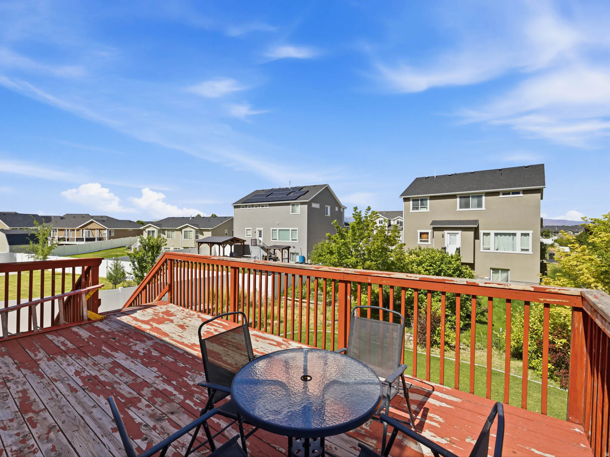 Wood-finish deck with red-stained railings and staircase
