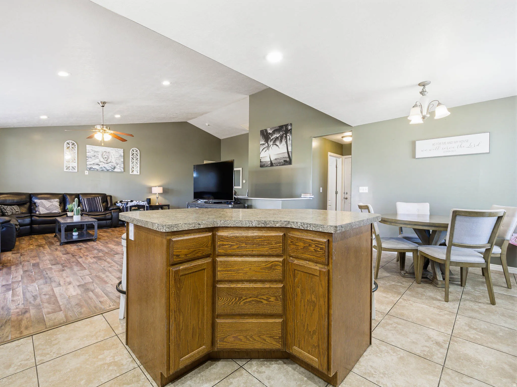 Kitchen island with wood-finish cabinetry and a speckled countertop