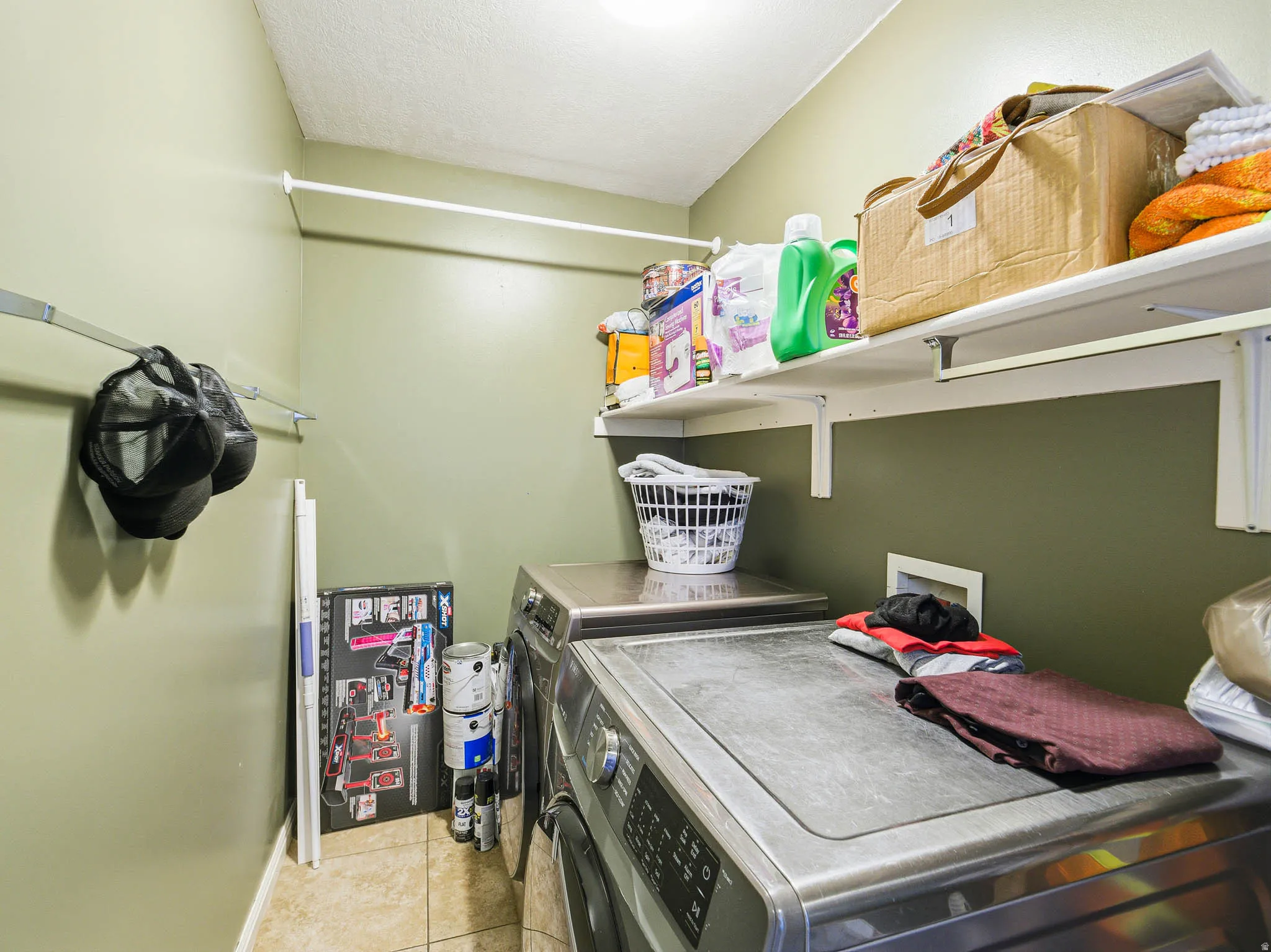 Laundry area featuring neutral-toned walls, tile flooring, and a white ceiling
