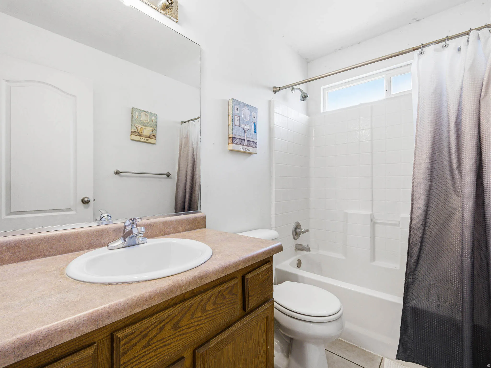 Bathroom featuring a wood-finish vanity with an integrated sink and chrome faucet