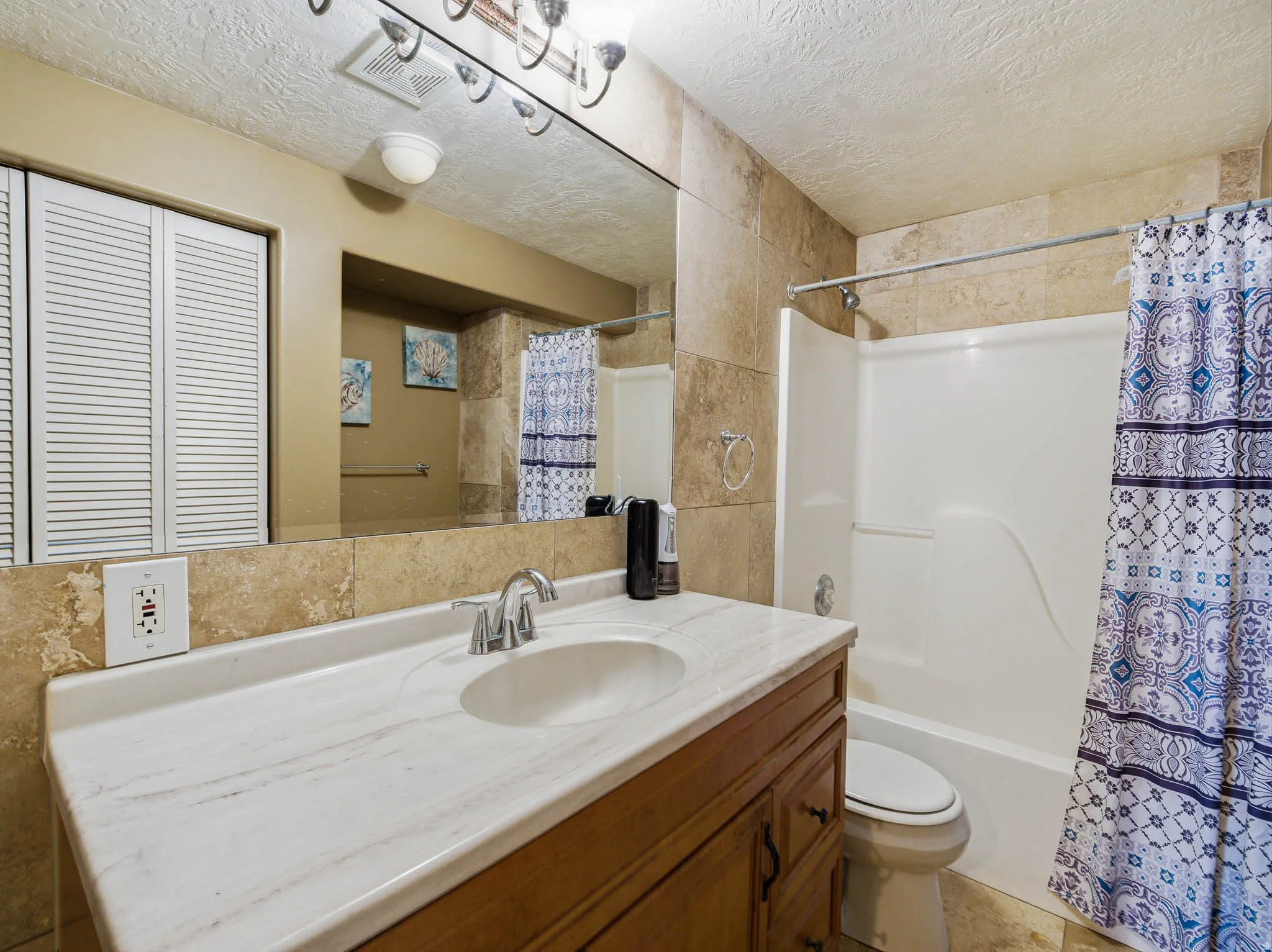 Bathroom featuring a white integrated sink, a dark wood-finish vanity, and a large wall-mounted mirror