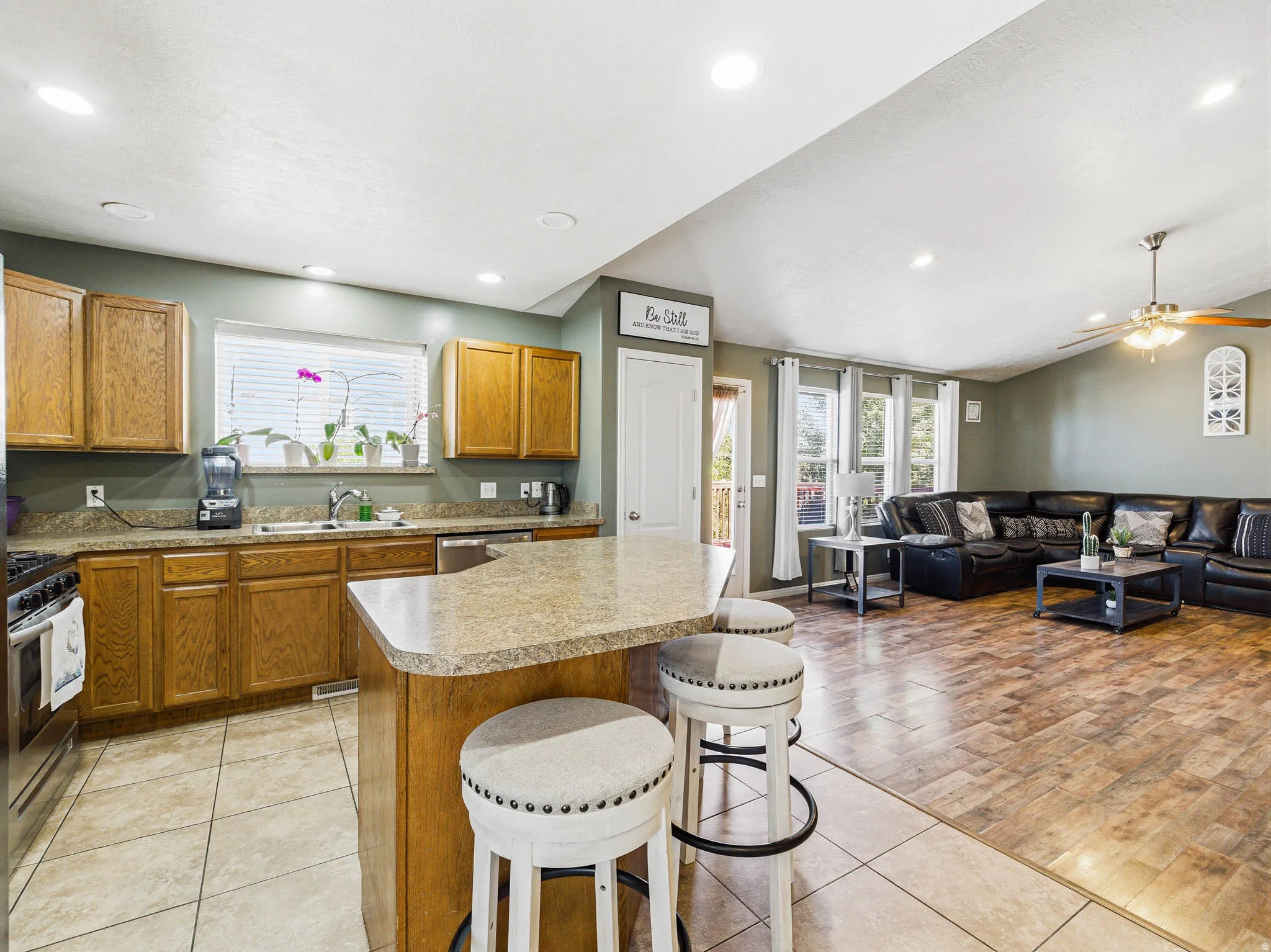 Open-concept living area with a kitchen island featuring a countertop, integrated sink, and stainless steel appliances