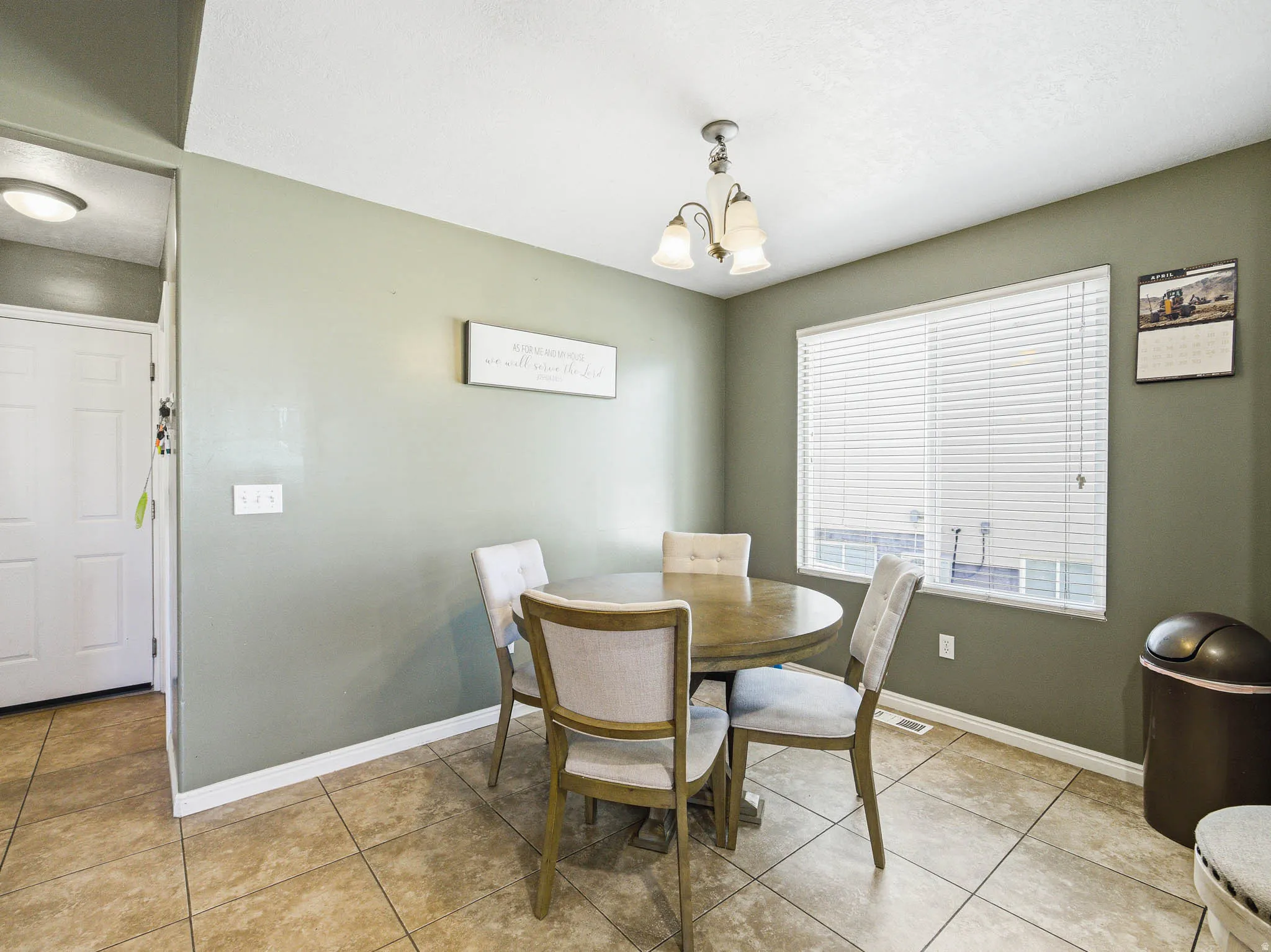 Dining area featuring a window with blinds, a ceiling-mounted light fixture, and tile flooring