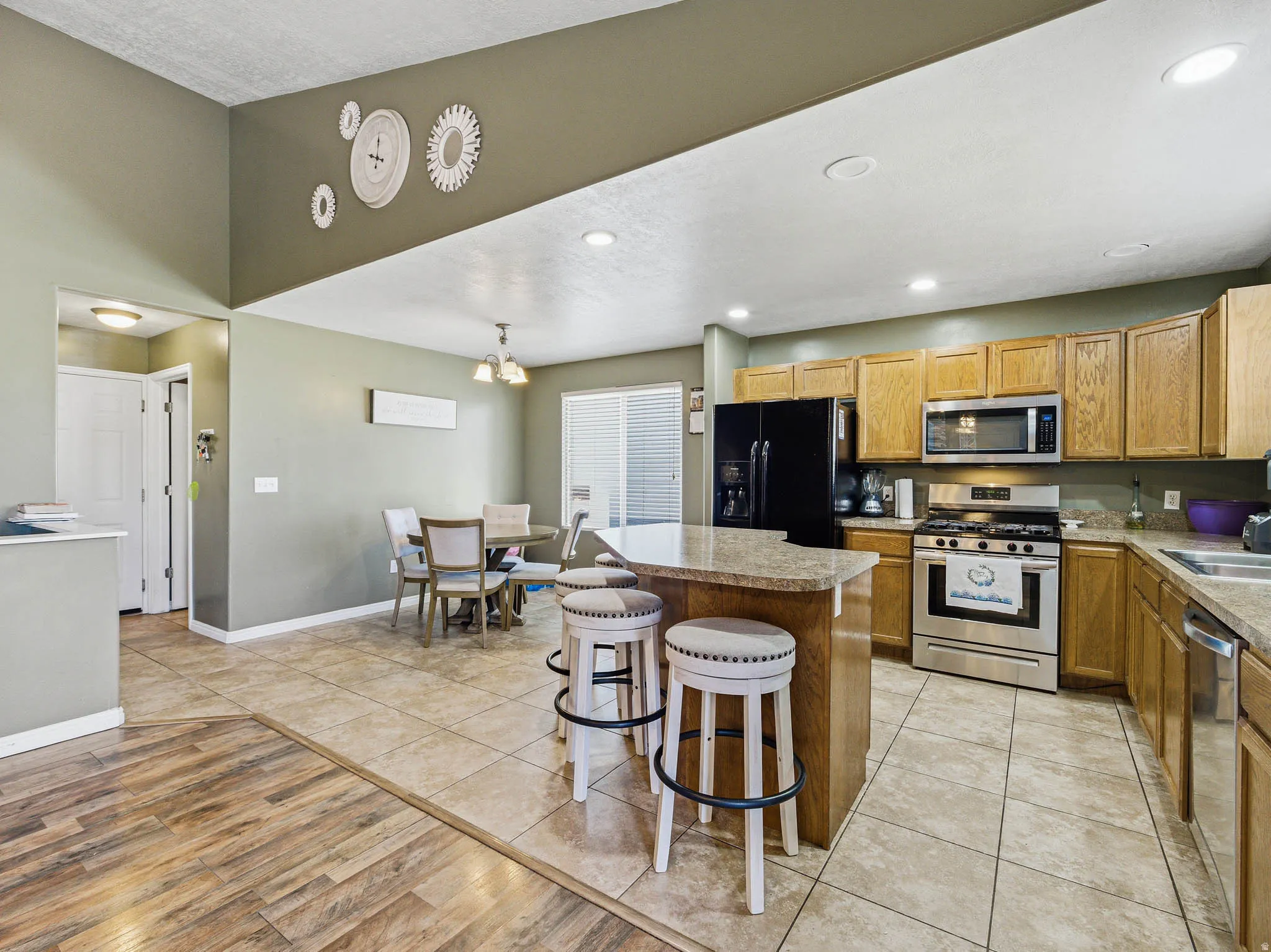 Kitchen featuring a peninsula with countertop seating, stainless steel appliances, wood cabinetry, and recessed lighting