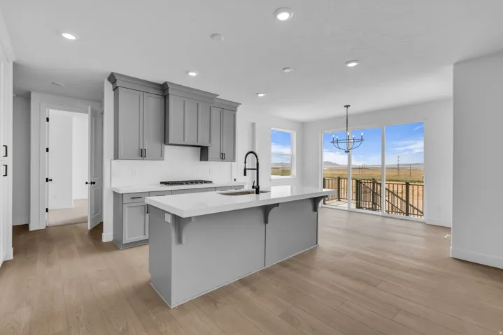 Full height kitchen cabinetry with beautiful crown molding, white Quartz countertops, and a subway tile backsplash, custom gas cooktop and double wall ovens.  Custom industrial style pull-down kitchen faucet.