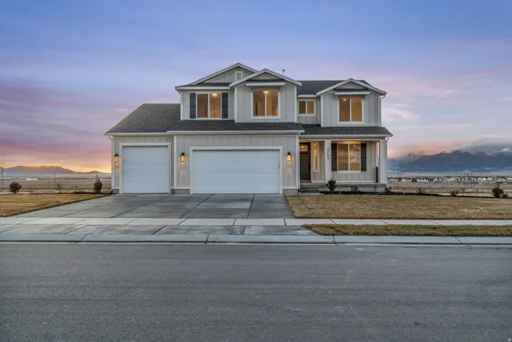 Two-story farmhouse style residence featuring a large covered front porch with beautiful mountain views.  Front yard landscaping is installed.