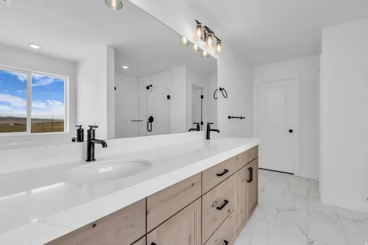 Primary bathroom with dual vanity and integrated sinks, white Quartz countertops, and a wood-finish base featuring matte black hardware.