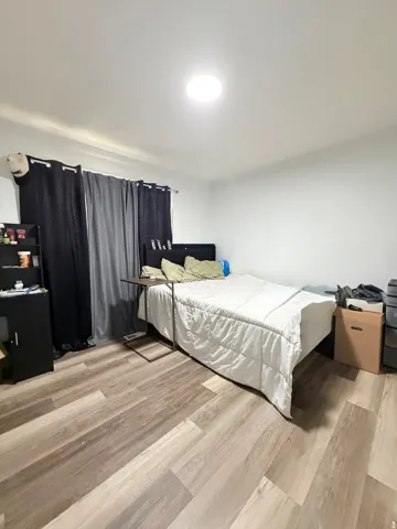 Interior space featuring light wood-finish flooring, white walls, and a ceiling-mounted light fixture
