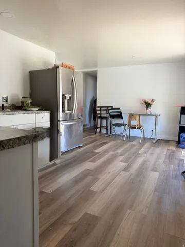 Open-concept kitchen area featuring wood-finish flooring, white walls, and recessed lighting