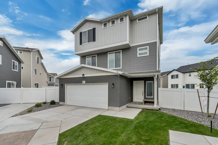 Contemporary three-story residence featuring a two-tone facade with dark gray stucco and light gray siding