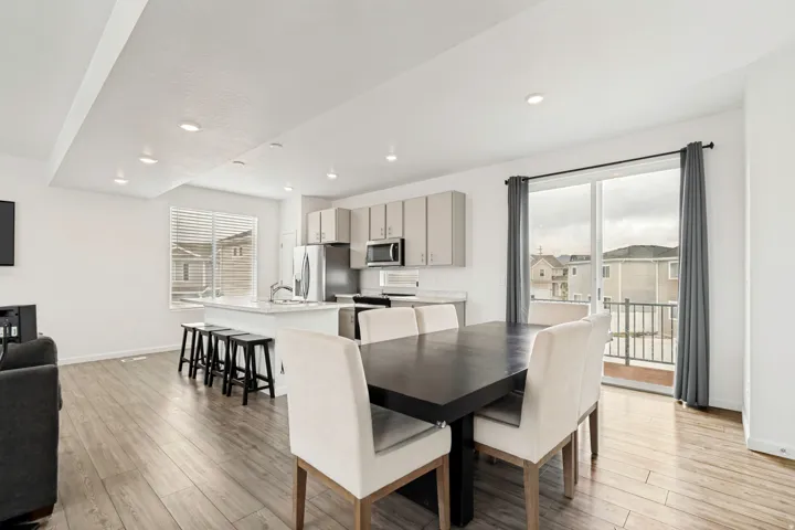 Open-concept living area featuring wood-finish flooring, recessed lighting, and a kitchen island with seating