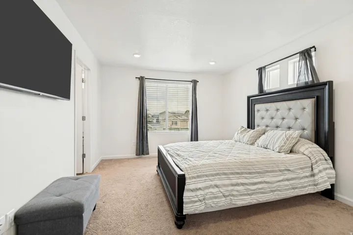 Spacious room featuring neutral carpet flooring, recessed lighting, and white walls