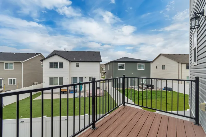 Expansive outdoor deck featuring wood-finish flooring and black metal railings
