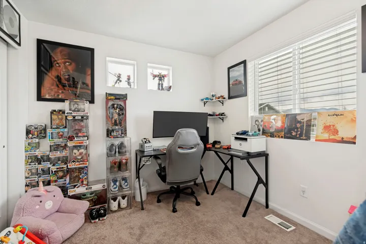 Bright room featuring a large window with horizontal blinds, neutral carpet flooring, and white wall finishes