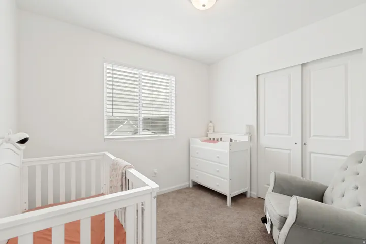 Neutral-toned room with carpet flooring and a window featuring white blinds
