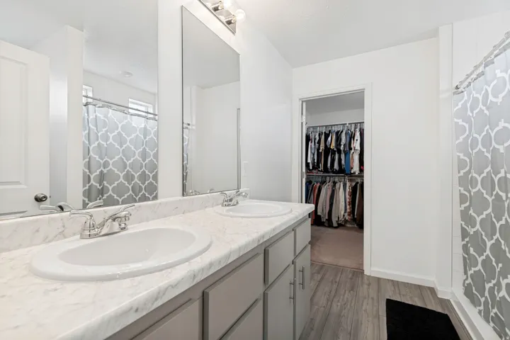 Dual vanity with a stone-finish countertop, undermount sinks, and chrome fixtures