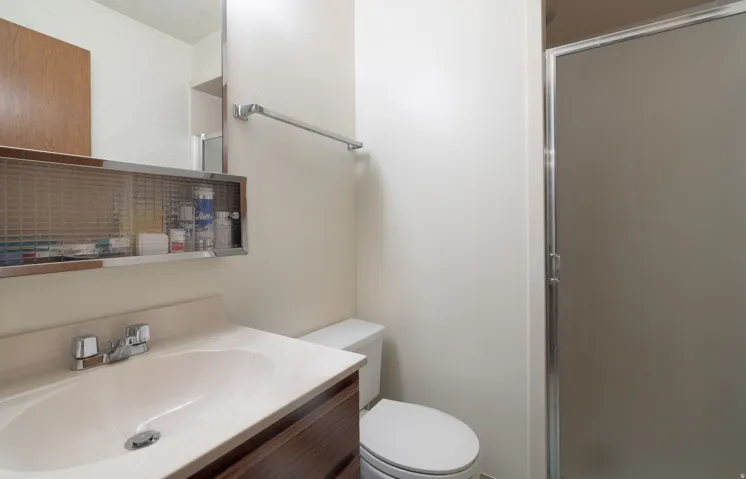Bathroom featuring a vanity with an integrated sink, a wood-finish cabinet, and a mirrored medicine cabinet