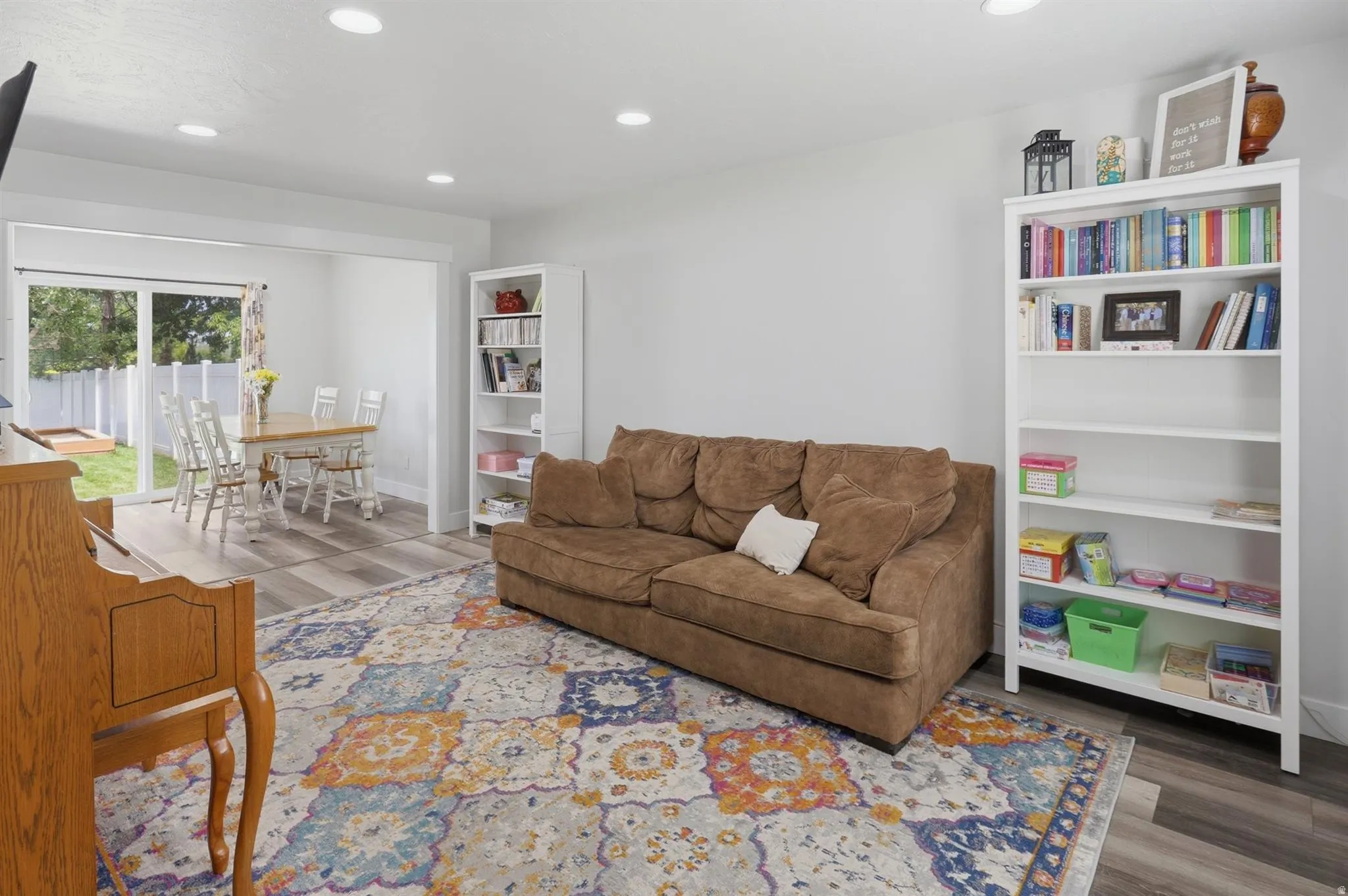 Open-concept living space featuring recessed lighting, wood-finish flooring, and white built-in shelving