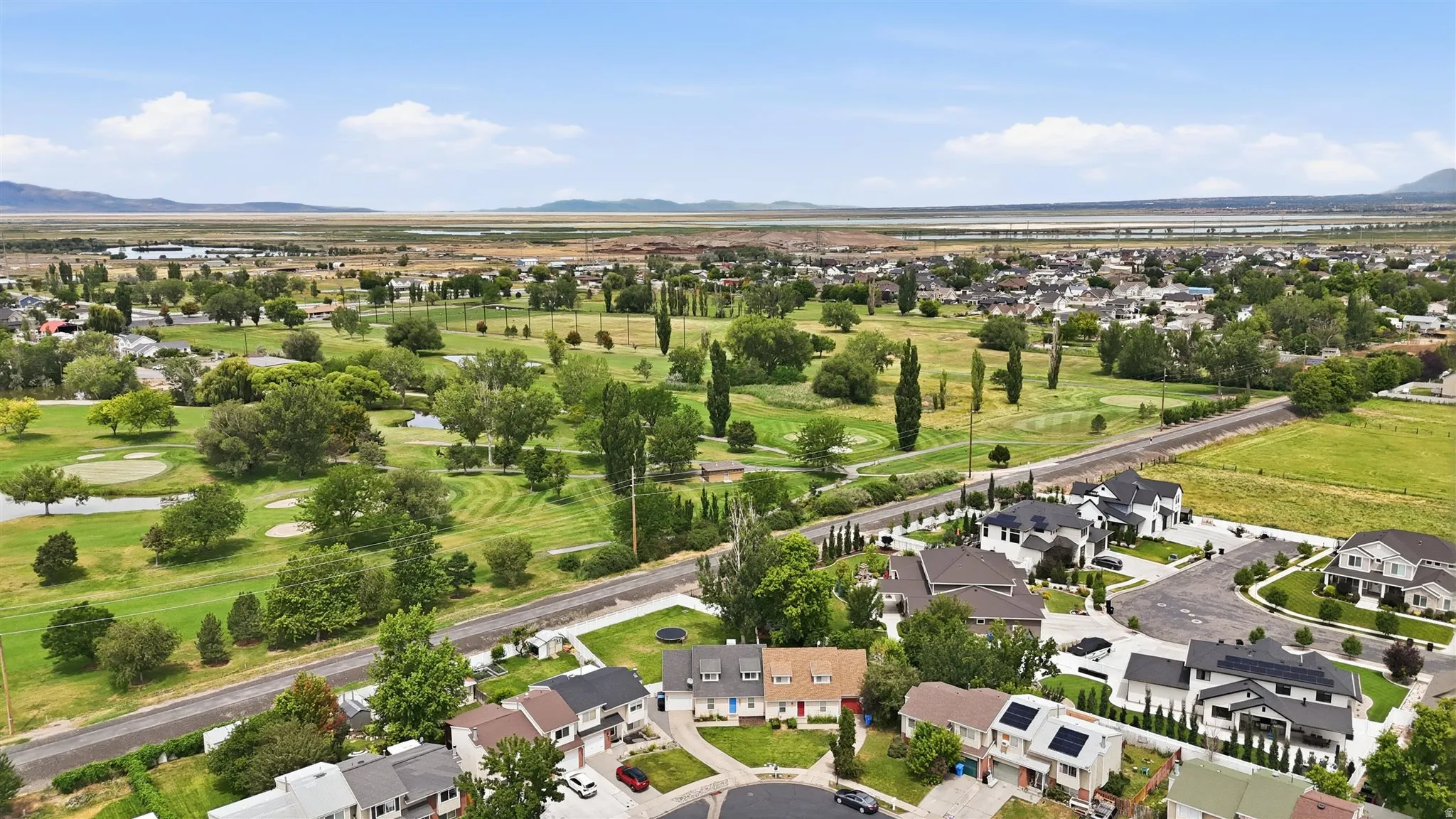 Expansive aerial overview showcasing a residential community bordering a golf course