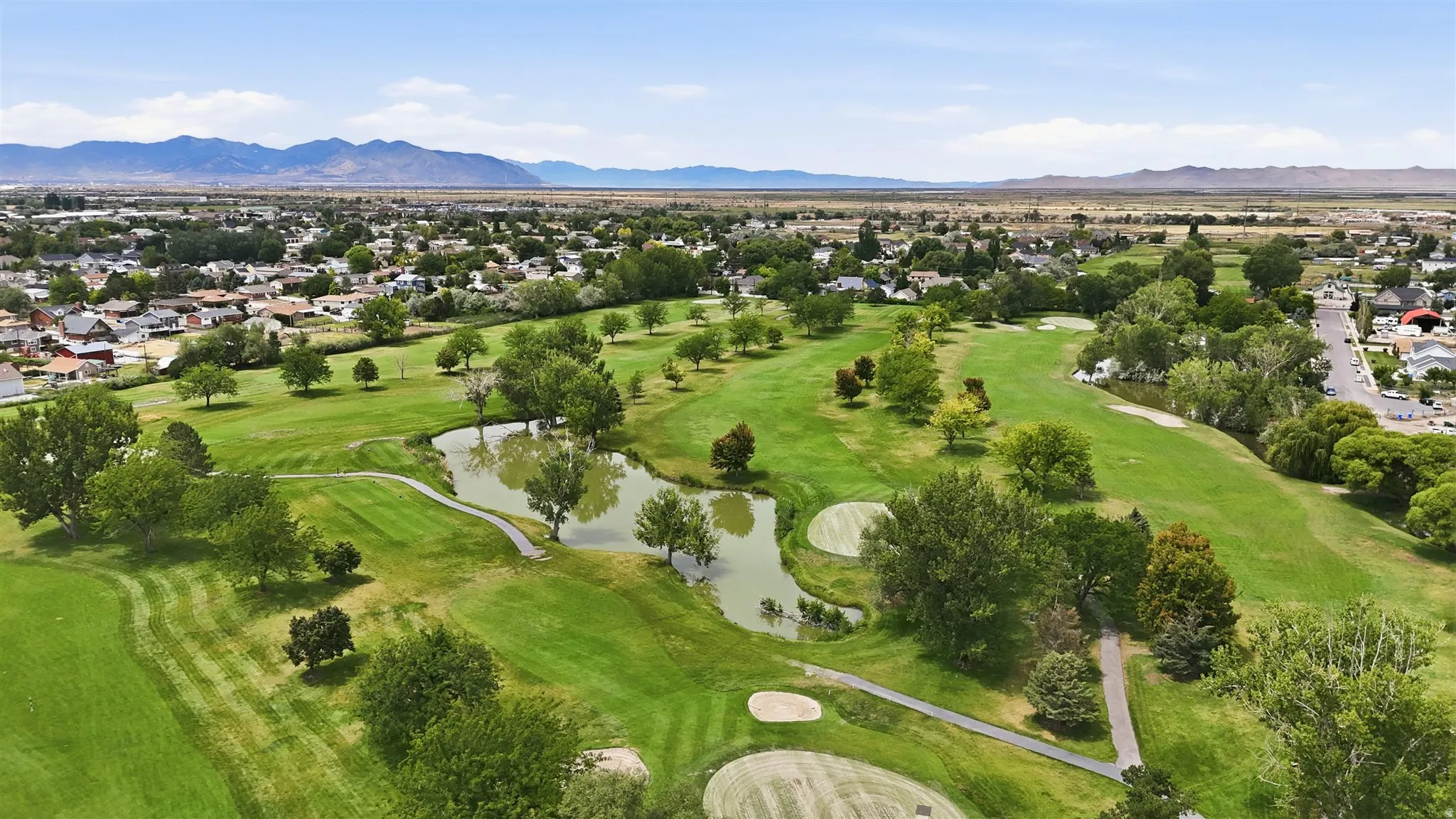 Expansive golf course featuring multiple greens, sand traps, and water features
