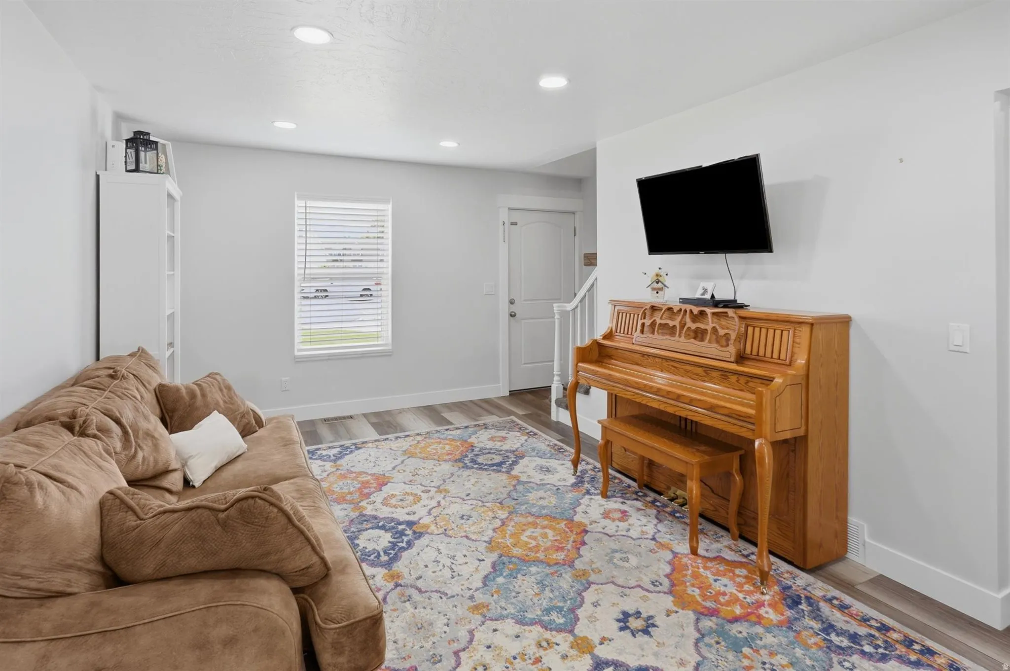 Inviting living space featuring wood-finish flooring, recessed lighting, and a white baseboard trim