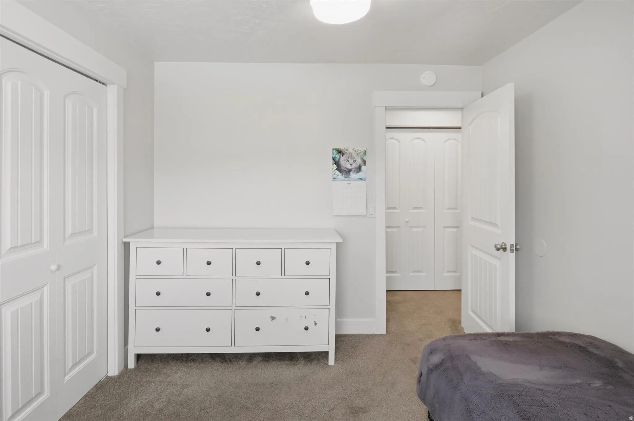 Interior room featuring neutral wall paint, a built-in closet with bifold doors, and carpet flooring