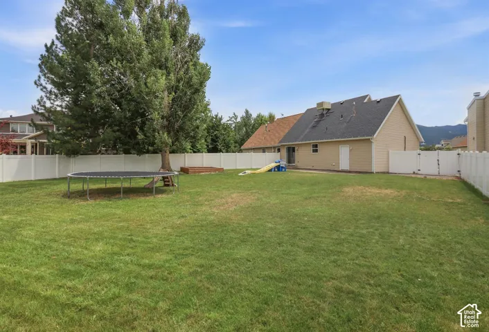 Expansive green lawn surrounded by a white vinyl privacy fence