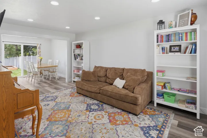 Open-concept living space featuring recessed lighting, wood-finish flooring, and white built-in shelving