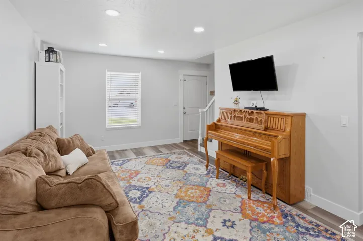 Inviting living space featuring wood-finish flooring, recessed lighting, and a white baseboard trim