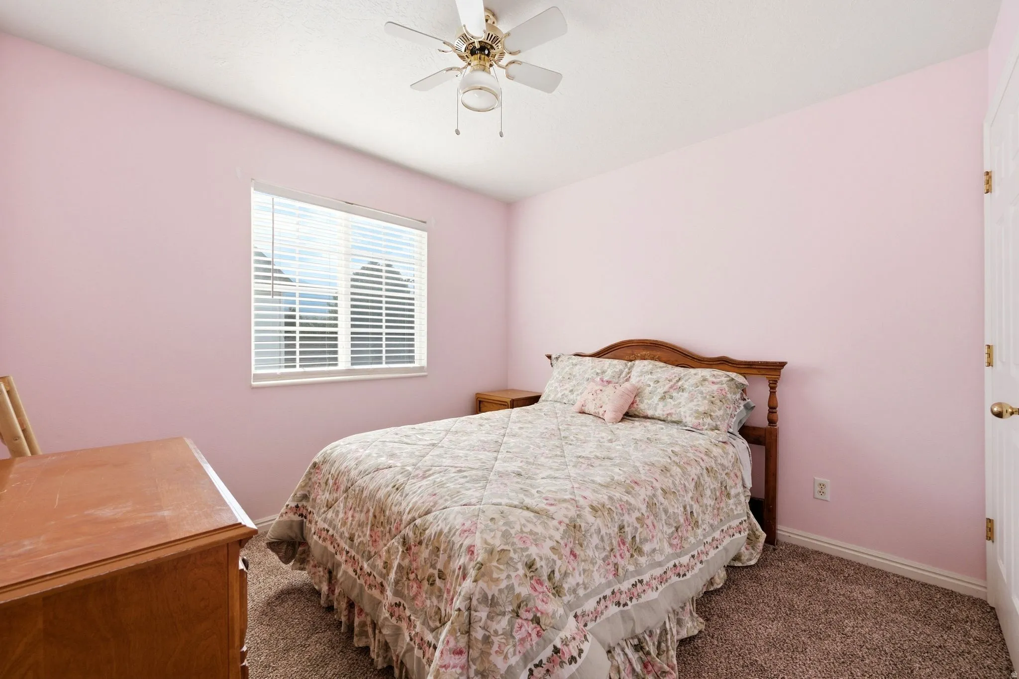 Bedroom featuring a ceiling fan, window with horizontal blinds, and textured wall finish