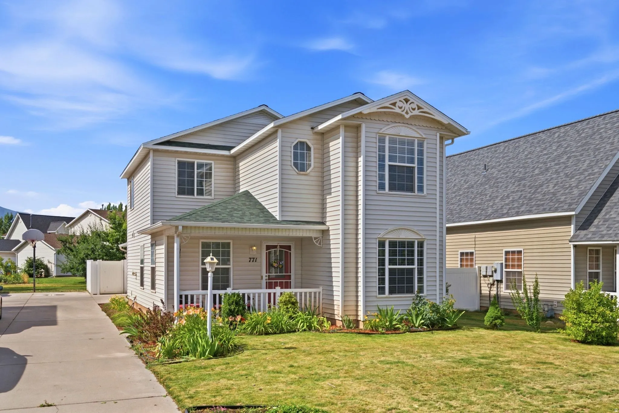 Two-story residence featuring light-colored siding and a green shingle roof