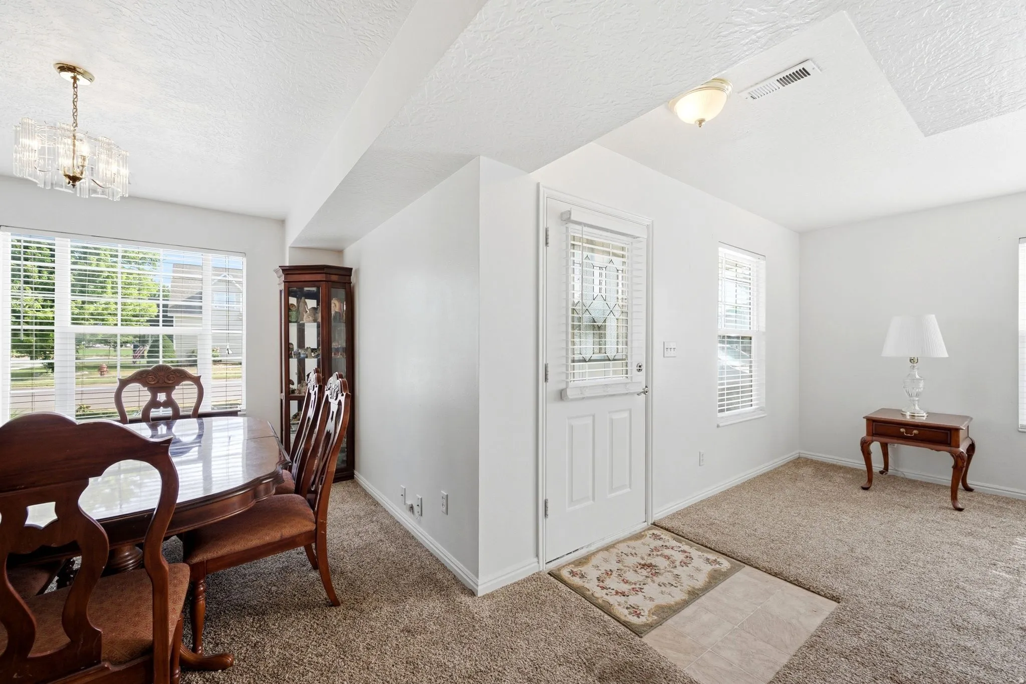 Bright interior space featuring light-colored carpet flooring and white walls