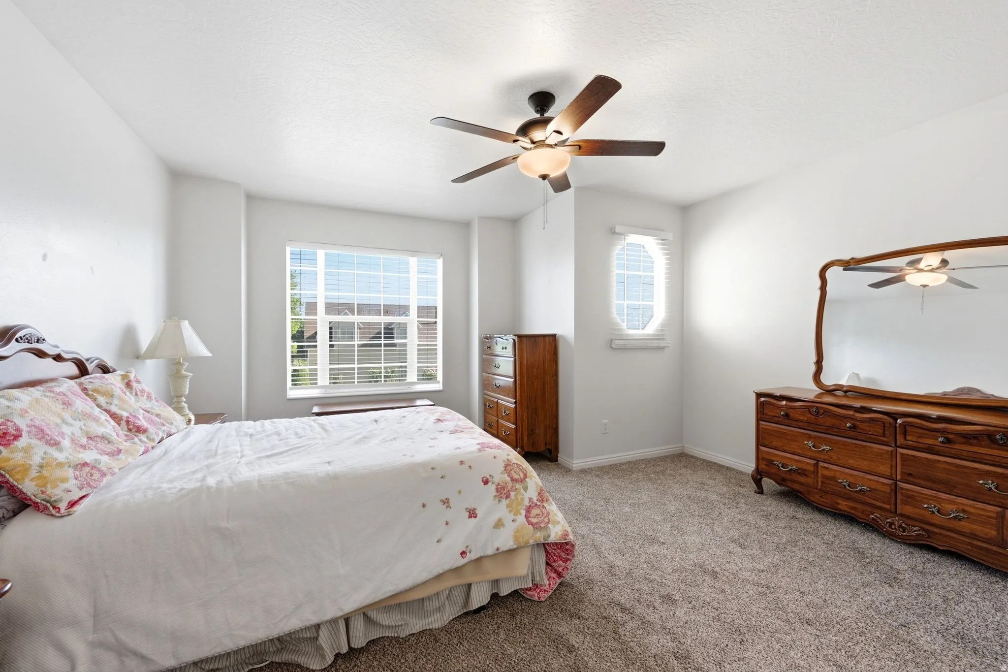 Carpeted bedroom with a large multi-pane window featuring blinds