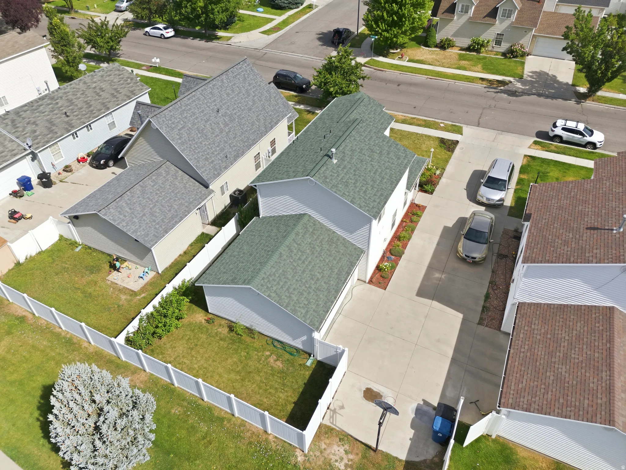 Two-story property with a green shingle roof and a concrete driveway