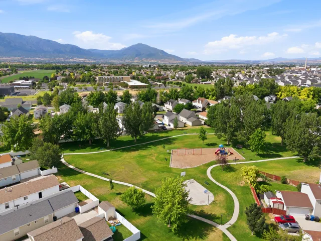 Expansive community park featuring a playground, basketball half-court, and walking paths
