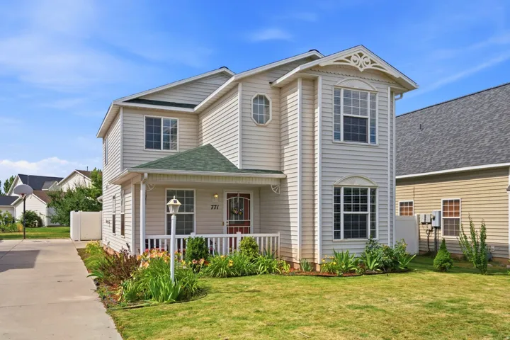 Two-story residence featuring light-colored siding and a contrasting green-shingled roof over the covered front porch