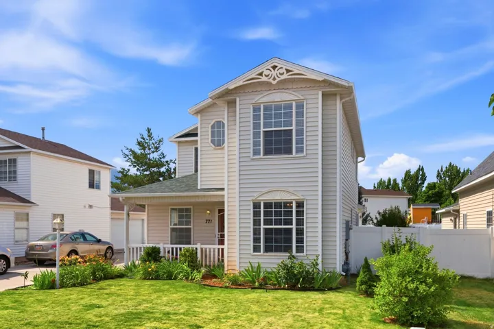 Two-story residence featuring light-colored siding and decorative gable trim