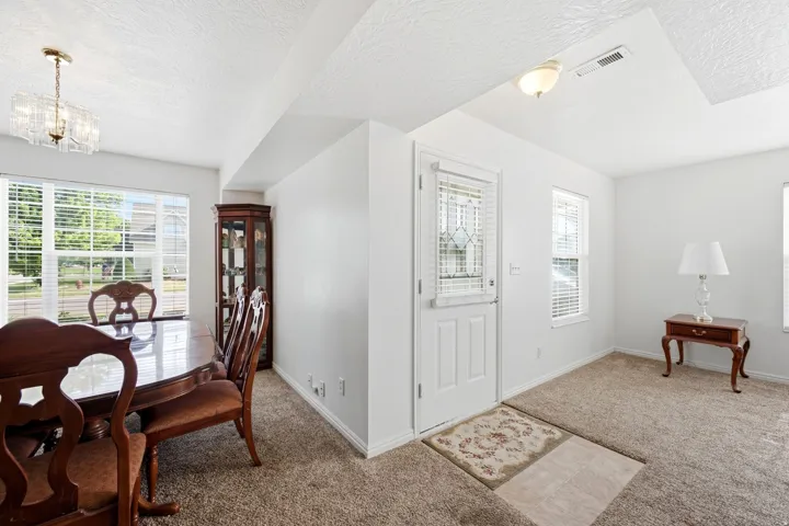 Bright interior space featuring light-colored carpet flooring and white walls
