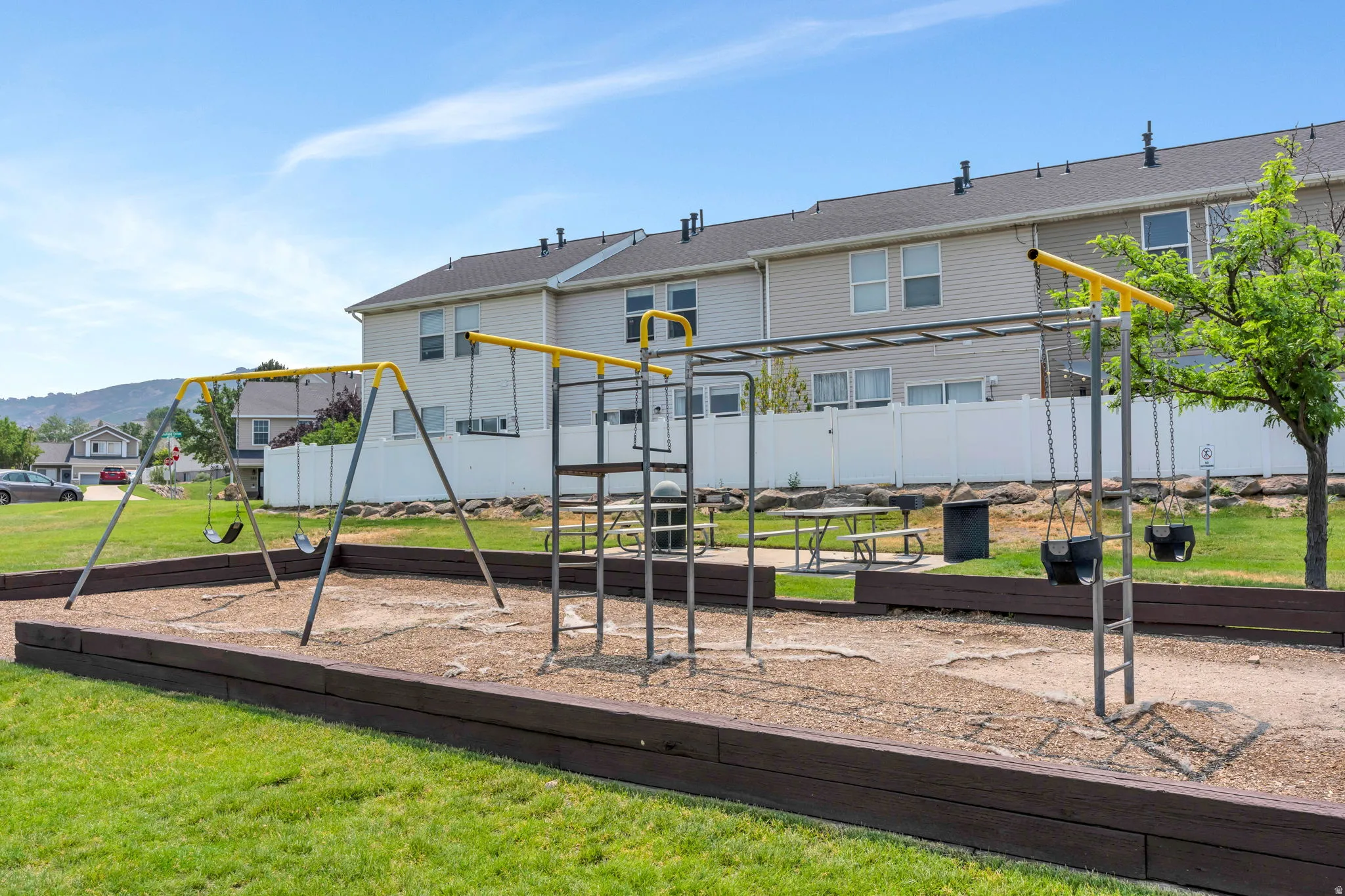 Recreational playground area featuring swing sets, monkey bars, and a picnic table