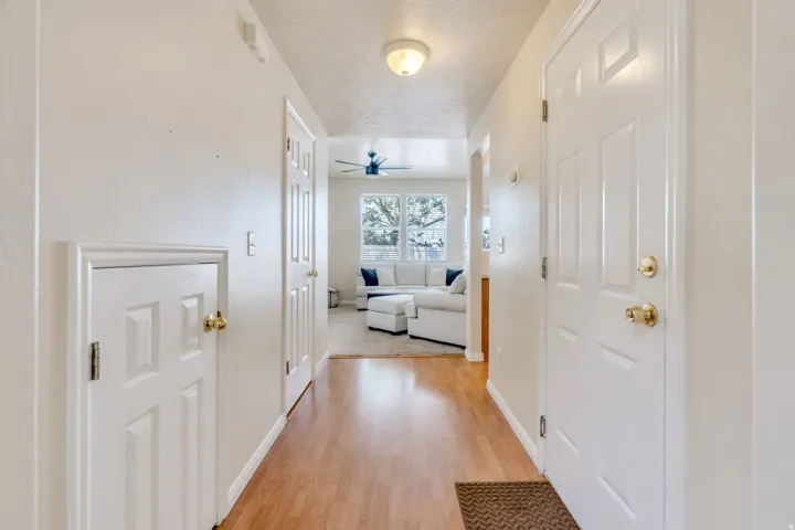 Entryway featuring wood-finish flooring, white paneled doors, and ceiling-mounted lighting