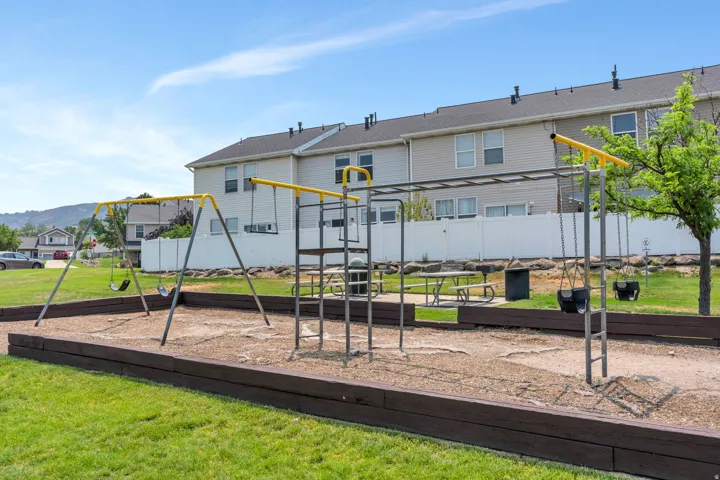 Recreational playground area featuring swing sets, monkey bars, and a picnic table