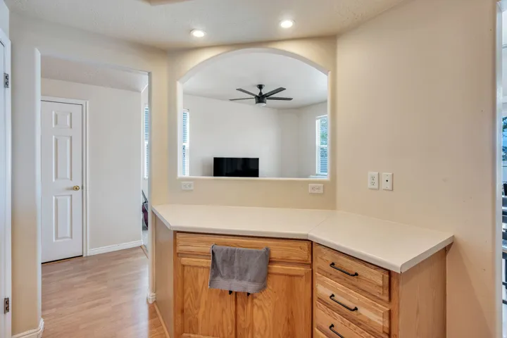 Kitchen pass-through with light wood-finish cabinetry and light-toned countertops