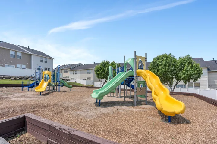 Community playground featuring multiple slides, climbing structures, and wood-chip surfacing