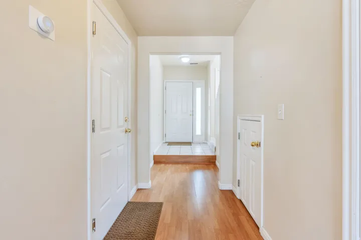 Light wood-finish flooring extending through a hallway with neutral wall tones